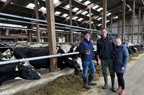 SCHAUMANN-Fachberater Hendrik Cordes (l.) und die Betriebsleiter der Schuhmacher GbR stehen im Milchviehstall